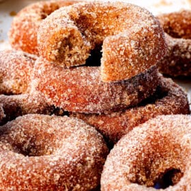apple cider donuts recipe with a bite taken out of the donut showing how tender and fluffy it is inside
