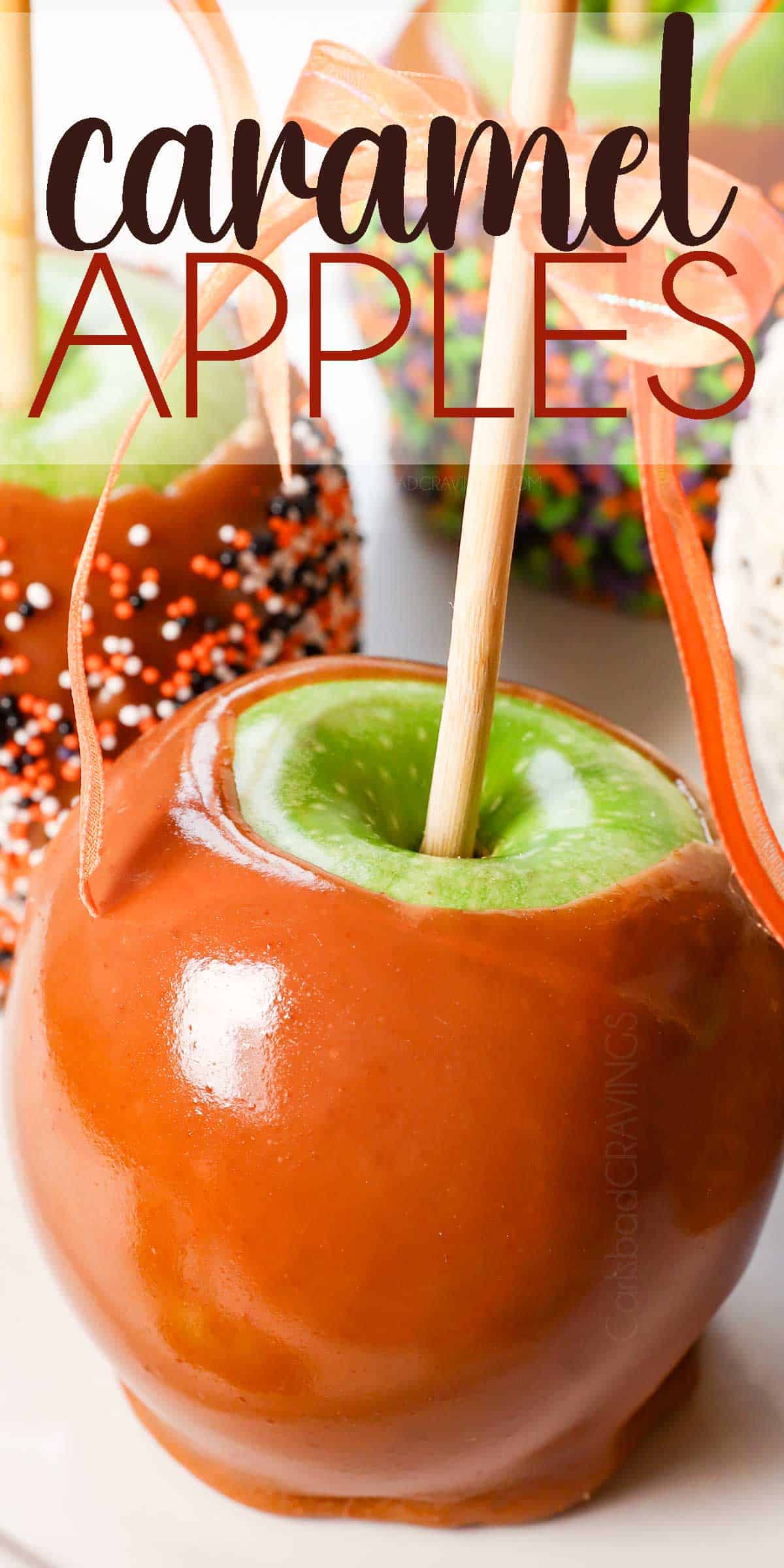 up close of a caramel apple dipped in caramel with a bow tied around the stick