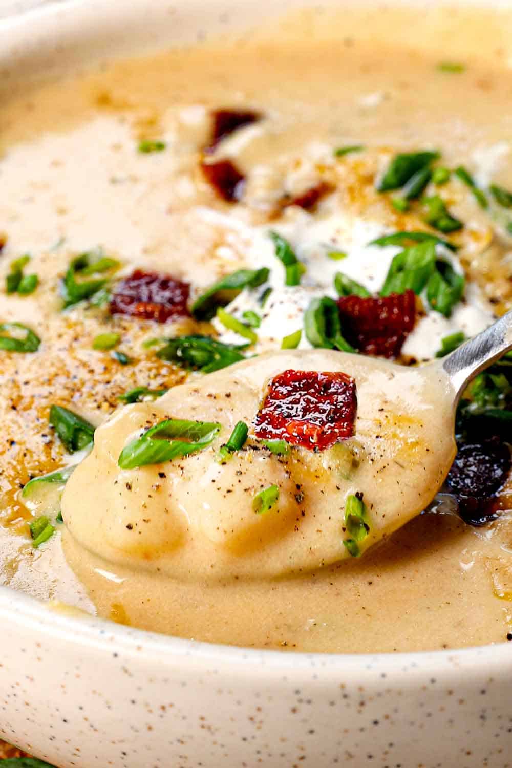 up close of a spoonful of baked potato-soup showing the chunks of potatoes