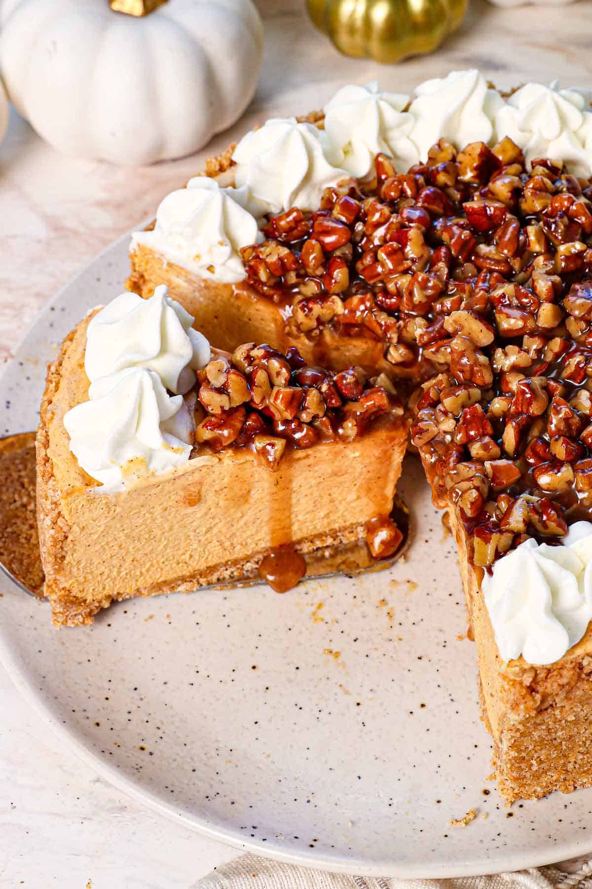 a slice of No Bake Pumpkin Cheesecake on a platter with the cheesecake