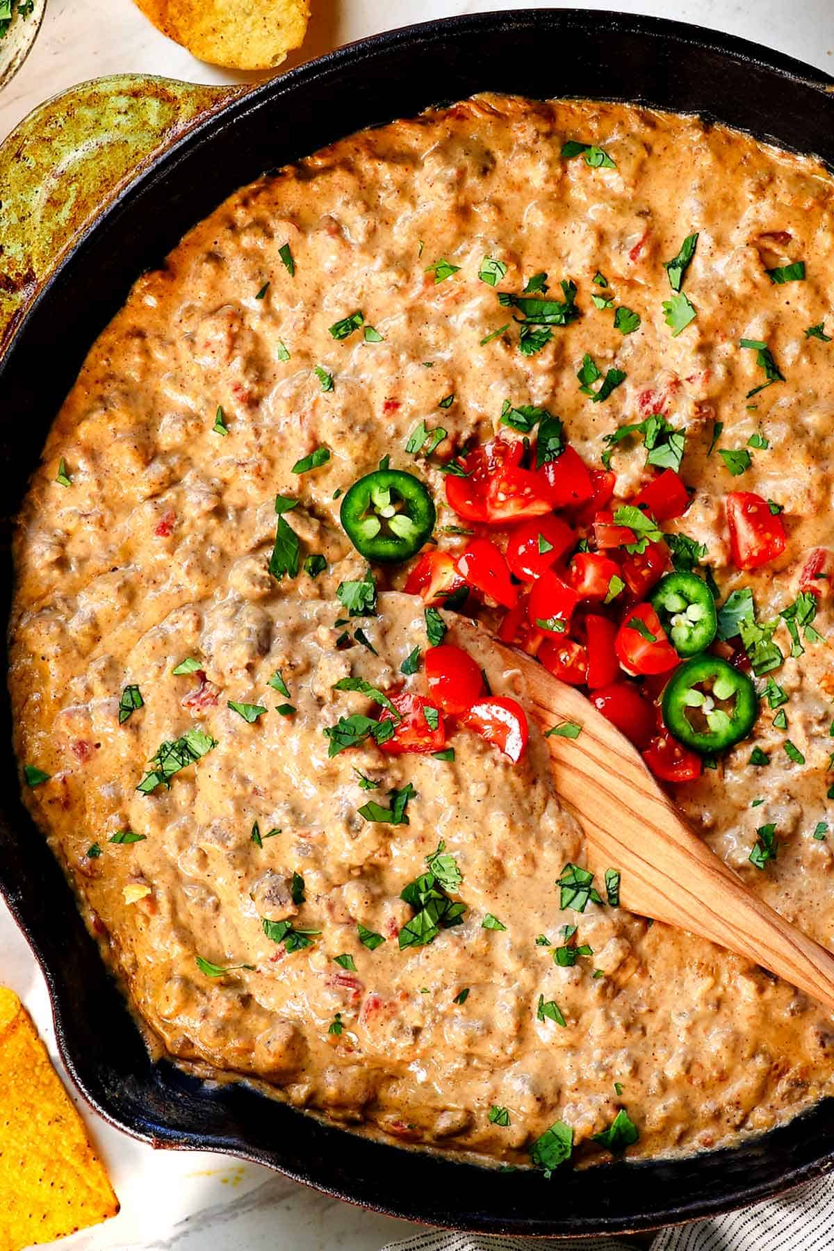 showing how to make Rotel Dip by topping with diced tomatoes and cilantro