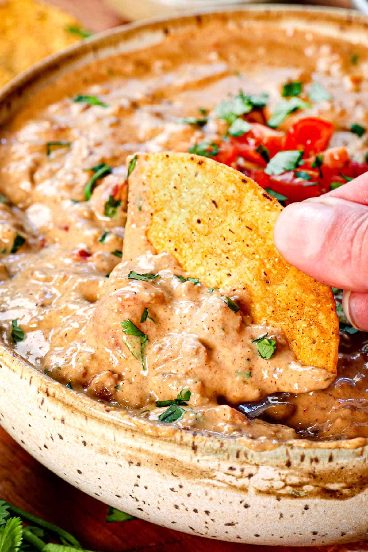a chip scooping best ever Rotel Dip Recipe showing how creamy it is