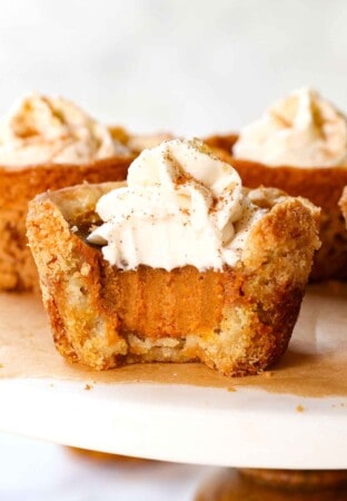 up close of a mini pumpkin pie with a bite taken out of it showing the creamy, silking pumpkin pie filling