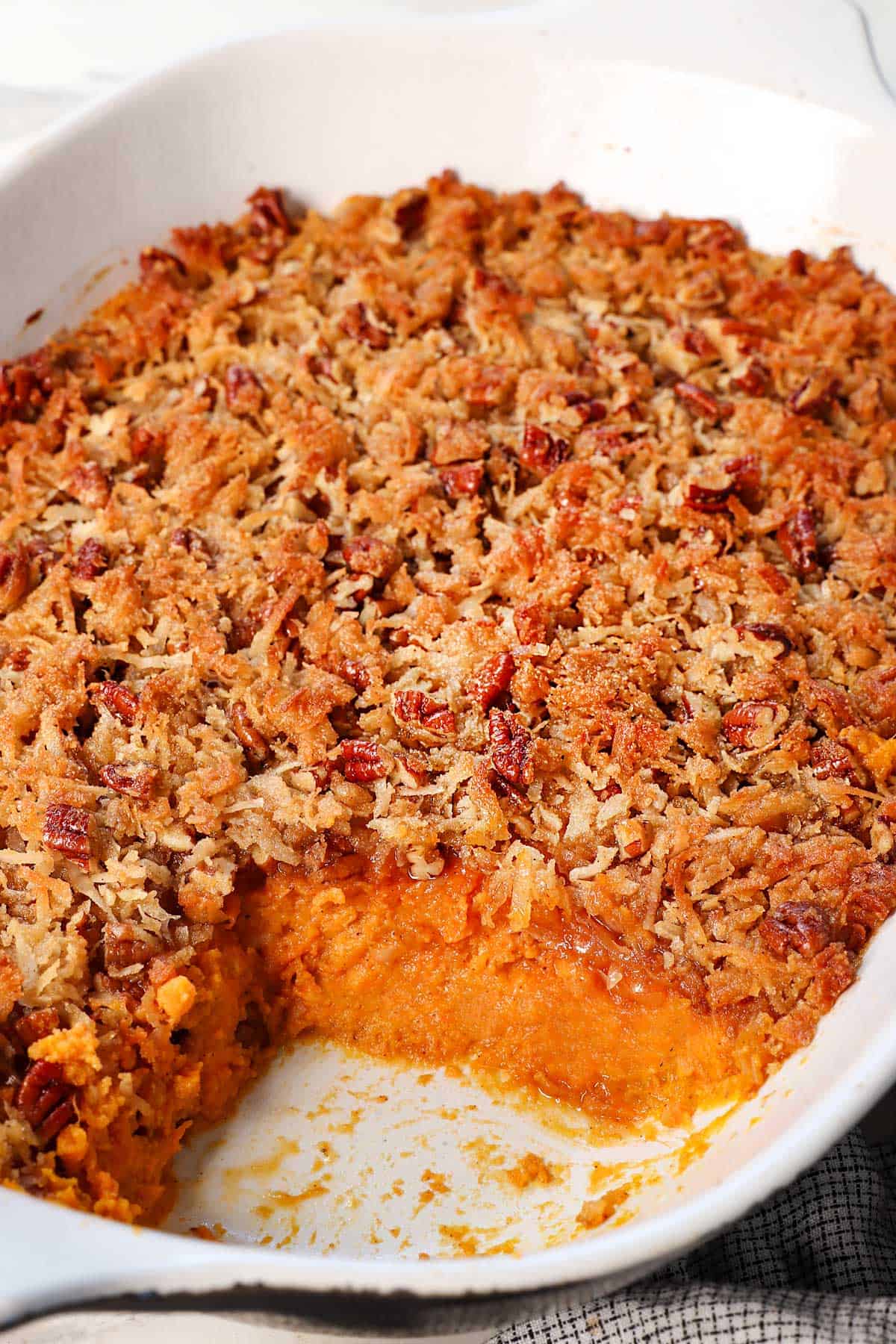 showing baked sweet potato casserole with some removed, showing how creamy the filling is