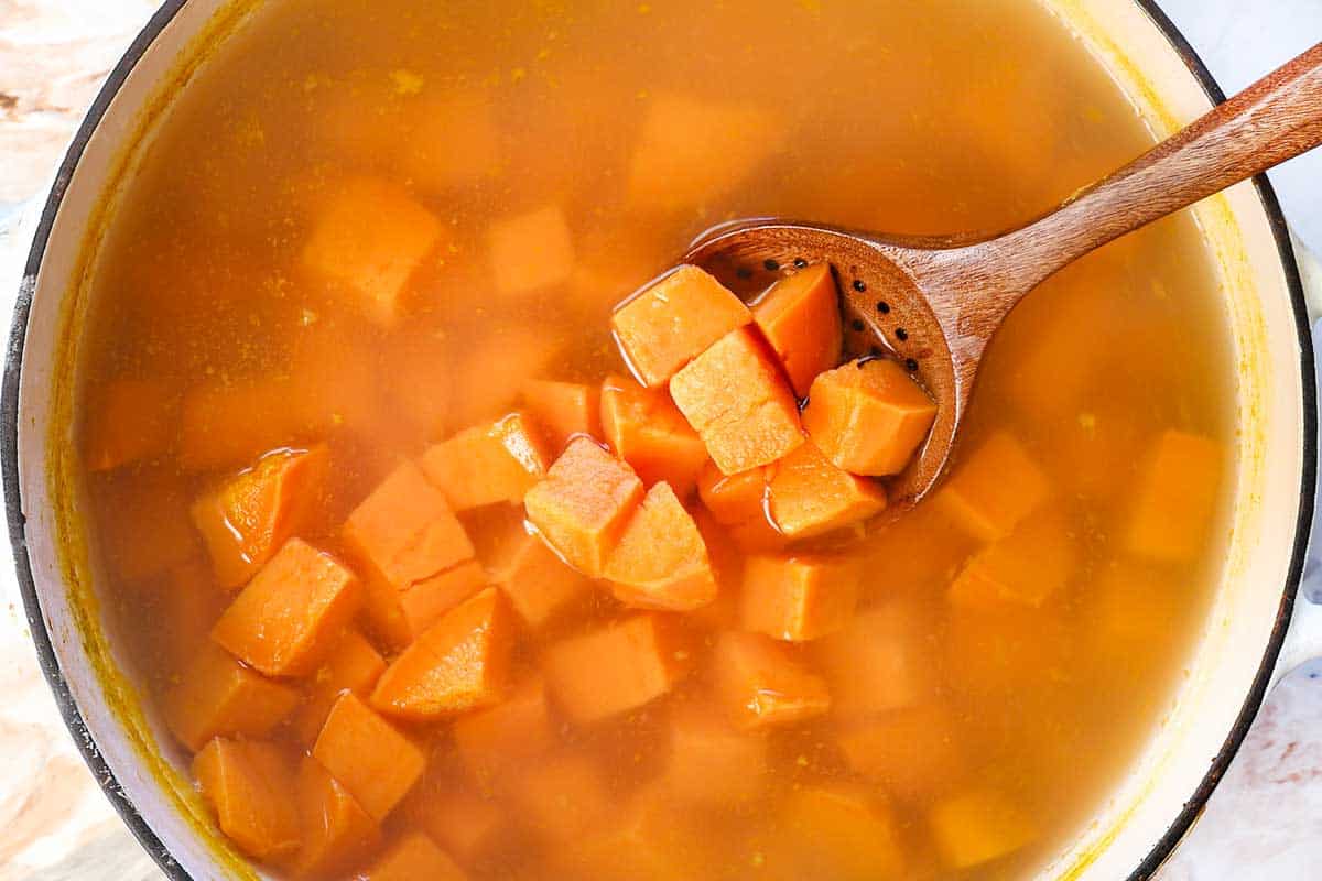 Showing how to make Sweet Potato Casserole by boiling the cubed sweet potatoes until tender