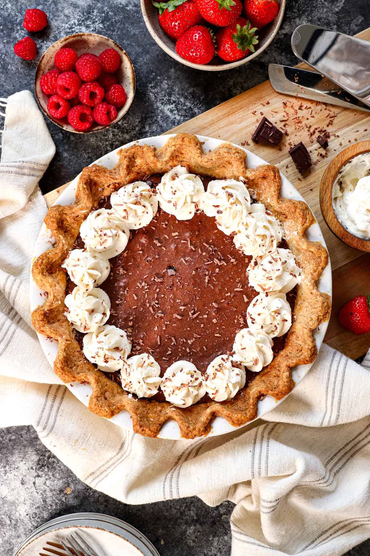 showing how to make chocolate chess pie by cooling then topping with a border of whipped cream
