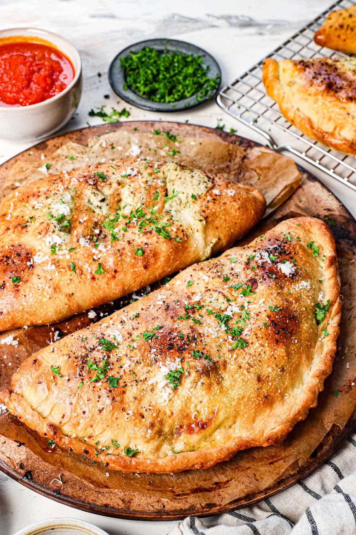 calzone calzone on a pizza stone showing how puffed up and golden they are