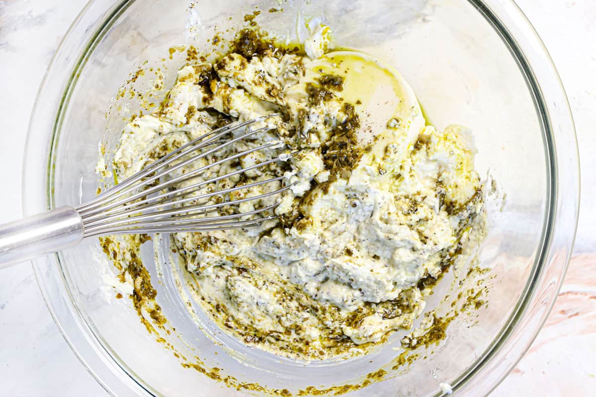 showing how to make calzone recipe by whisking together the ricotta sauce